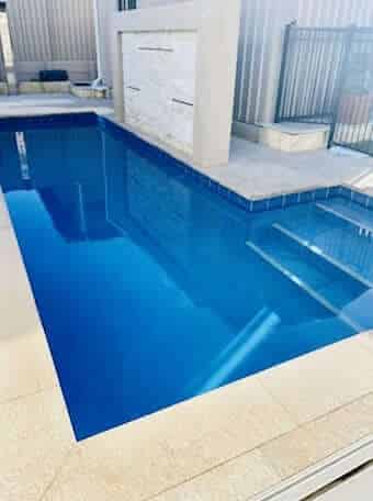 Clear aqua blue swimming pool which is being heated shallow side view.